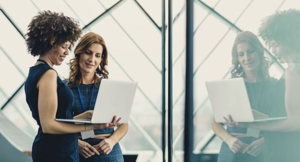 Two Businesswomen Working in The Office, Using Laptop