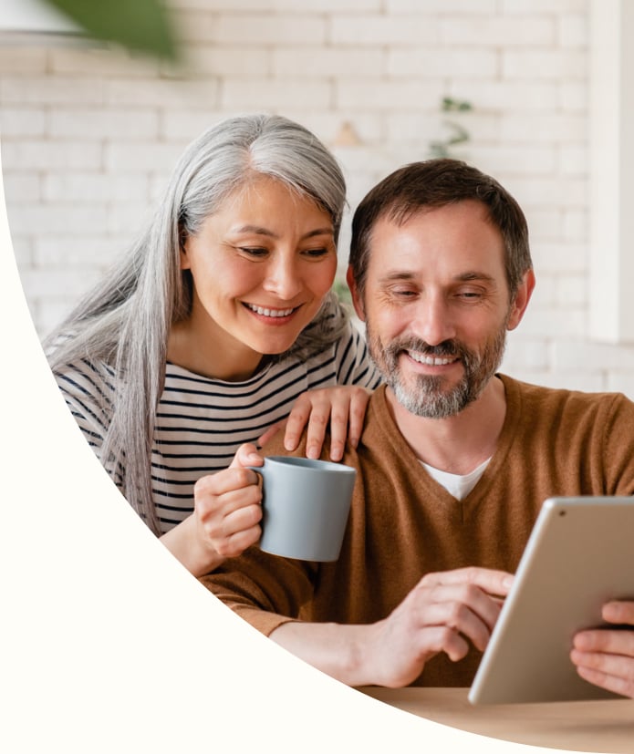 Mature couple reading news on digital tablet
