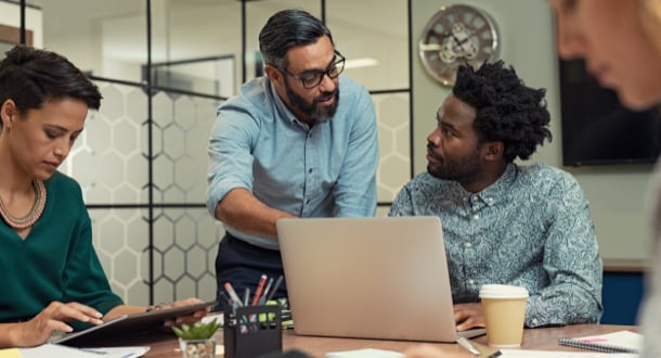 mature manager discussing with his colleague online data in front of laptop