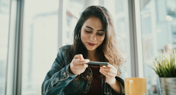 young Indian woman sends her paycheck to the bank via Remote Deposit Capture with her mobile phone