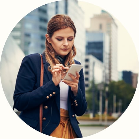 young woman using cell phone while commuting in the city