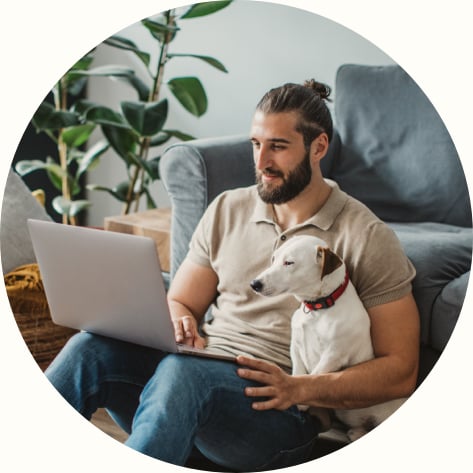 young male working on his laptop with his dog